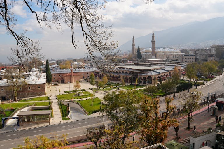Aerial view of Bursa showcasing the iconic Ulucami and Tophane amidst lush greenery and historic architecture.